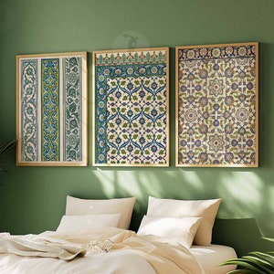 May include: Three framed prints with intricate geometric patterns in shades of blue, green, and white. The prints are arranged in a row on a green wall above a bed with white linens.