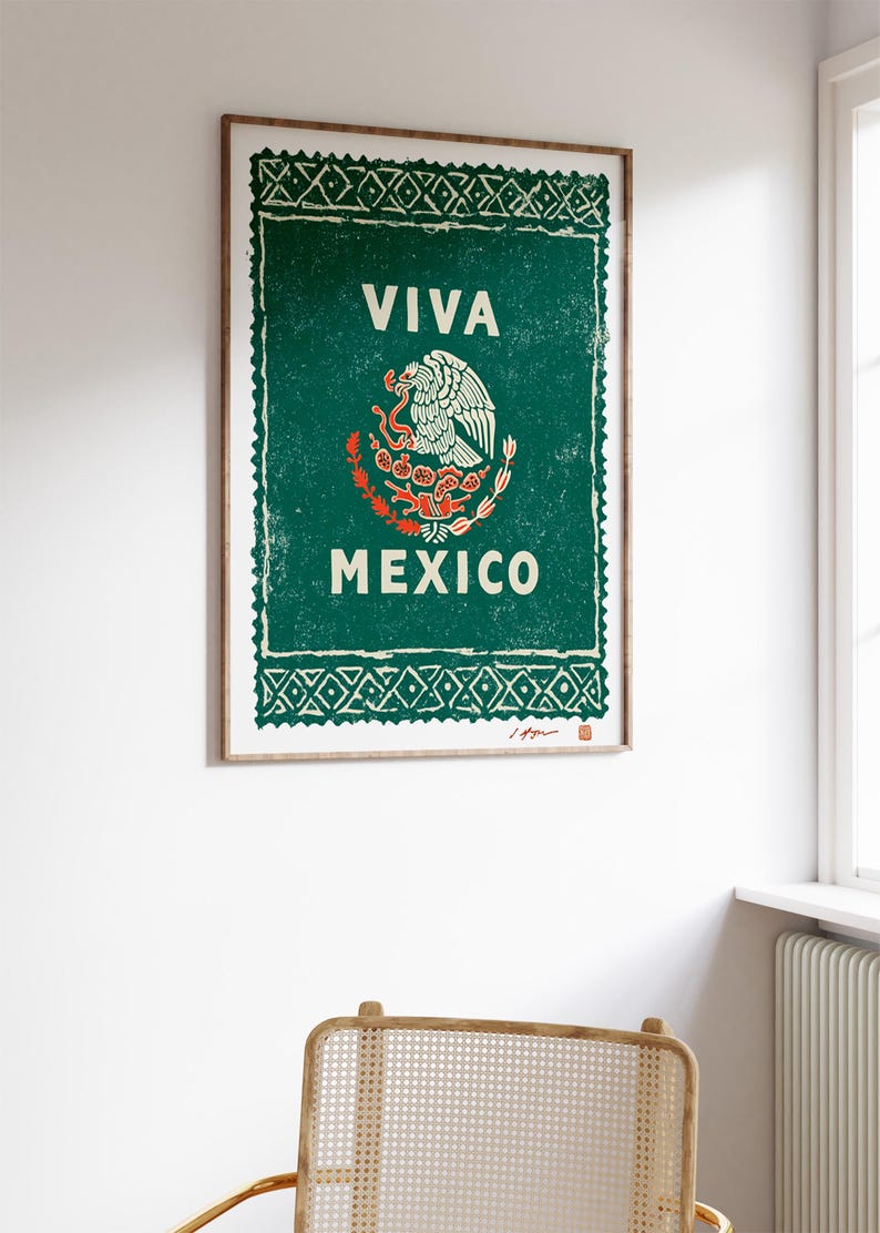 May include: A framed print with a green background and the words "VIVA MEXICO" in white. The print features the Mexican coat of arms, an eagle with a snake. The frame is a light brown color.