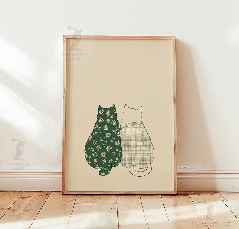 Puede incluir: Una impresi&oacute;n art&iacute;stica enmarcada con dos gatos estilizados. Uno tiene un estampado floral verde oscuro, el otro un estampado a cuadros gris claro. Los gatos est&aacute;n sentados juntos, de espaldas al espectador, sobre un fondo crema.