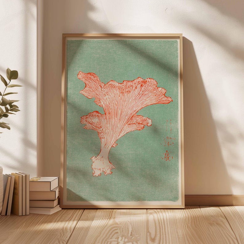 May include: A framed art print featuring a detailed illustration of a coral-colored mushroom against a muted green background. The artwork has a vintage aesthetic, with visible textures and a natural wood frame. The print is displayed indoors, leaning against a wall.