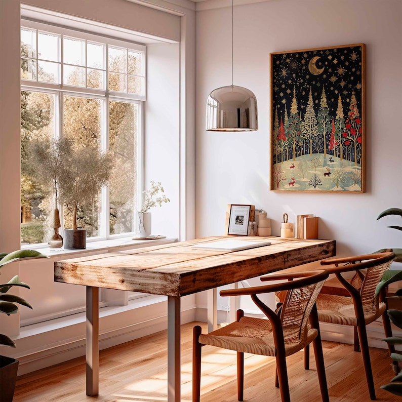 Op de afbeelding: Een houten tafel met een rustieke afwerking, met een zilveren hanglamp en twee stoelen met gevlochten zittingen. Een ingelijst afdruk van een bos sc&egrave;ne met een halve maan hangt aan de muur achter de tafel.