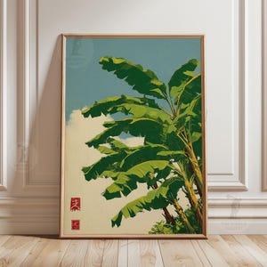 Op de afbeelding: Een ingelijste kunstdruk met een gestileerde weergave van bananenbladeren tegen een blauwe lucht met wolken. Het kunstwerk heeft een vintage esthetiek, met groene en gele tinten. De print bevat Japanse tekst in de linker benedenhoek.