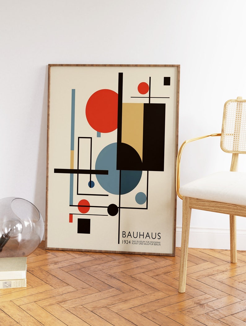 May include: A framed Bauhaus art print with a cream background, displaying geometric shapes in red, black, blue, and yellow. The print includes the text "BAUHAUS 1924 DAS MUSEUM FUR MODERNE KUNST UND SKULPTUR BERLIN". The frame is light brown.