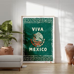 May include: A framed poster with a green background and the words "VIVA MEXICO" in white. The Mexican coat of arms is in the center. The poster has a distressed, vintage look, with a decorative border.