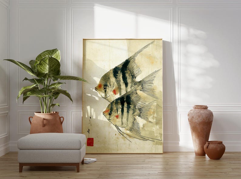 K&ouml;nnte beinhalten: Ein gerahmter Kunstdruck mit zwei stilisierten Fischen mit schwarz-wei&szlig;en Streifen und roten Akzenten. Das Kunstwerk hat einen Vintage-Aquarellstil mit einem beige-gelben Hintergrund. Der Druck wird in einem Raum mit einer Pflanze, einem Hocker und dekorativen Vasen ausgestellt.