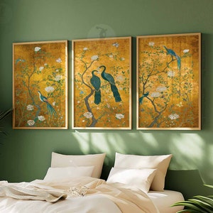 May include: Three framed prints with a gold background and a floral design featuring birds. The birds are blue and green with long tails. The prints are set against a green wall.