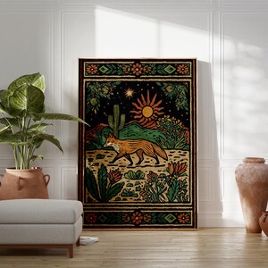 May include: A framed art print featuring a desert landscape with a fox, cactus, and sun. The artwork has a black background with orange, green, and yellow details. A large potted plant, a footstool, and two terracotta vases are in the foreground.