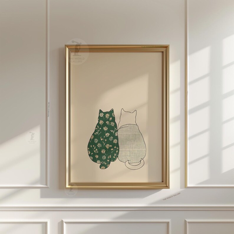 Puede incluir: Impresi&oacute;n art&iacute;stica enmarcada con dos gatos estilizados. Uno es verde con un estampado floral blanco, el otro gris claro con un patr&oacute;n de cuadr&iacute;cula. La obra est&aacute; enmarcada en dorado sobre un fondo beige.
