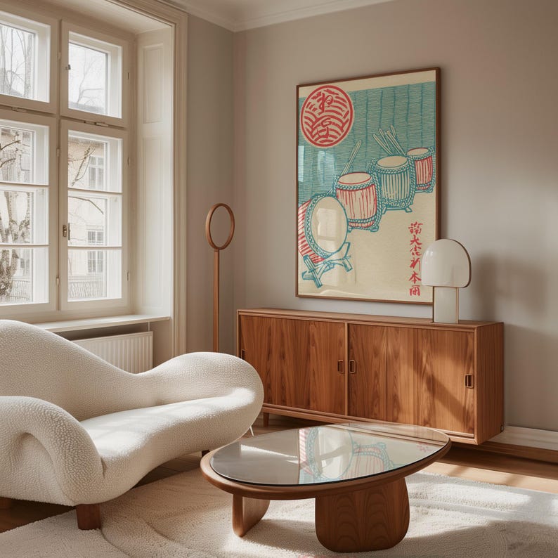 May include: A living room scene featuring a wooden cabinet, a white sofa, and a round coffee table. A framed artwork with Japanese text and drum illustrations hangs above the cabinet. A white lamp and a wooden floor lamp are also visible.