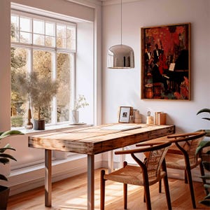 May include: A well-lit room with a wooden desk and two chairs. A framed painting of a jazz band hangs on the wall. A large window offers a view of trees. A silver pendant light hangs above the desk.
