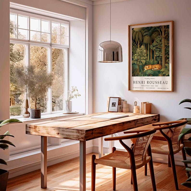 Puede incluir: Una habitaci&oacute;n con un escritorio de madera y dos sillas. Un cuadro enmarcado de Henri Rousseau cuelga en la pared. El cuadro representa un tigre en una escena de la jungla. Una gran ventana ofrece vistas de &aacute;rboles.