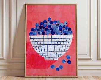 Könnte beinhalten: Ein gerahmter Kunstdruck mit einer Schale voller blauer Kugeln vor rotem Hintergrund. Die Schale hat ein weißes und blaues Karomuster. Mehrere blaue Kugeln sind darunter verstreut. Das Kunstwerk wird auf einem Holzboden ausgestellt.