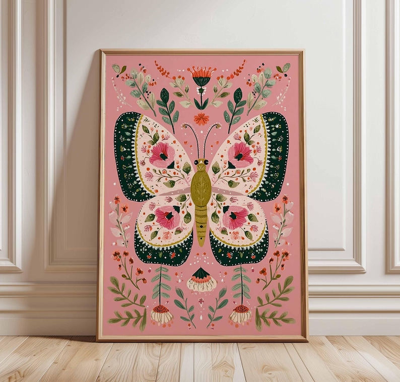 May include: A framed art print featuring a large butterfly with intricate floral patterns. The butterfly has pink, green, and cream-colored wings, set against a pink background. The artwork is surrounded by botanical elements.