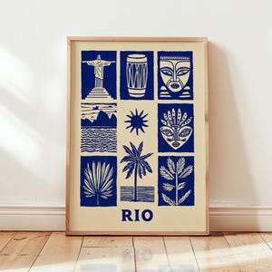 Puede incluir: Un estampado enmarcado con nueve ilustraciones en azul y blanco de monumentos y símbolos de Río de Janeiro. El estampado incluye la estatua del Cristo Redentor, un tambor, máscaras, un sol, una palmera y la palabra "RIO".
