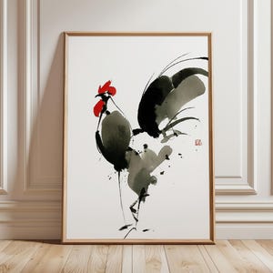 Puede incluir: Pintura en acuarela enmarcada de un gallo de estilo minimalista. La obra presenta una cresta y barbillas rojas, con pinceladas negras y grises que forman el cuerpo y las plumas. El gallo está sobre un fondo blanco.