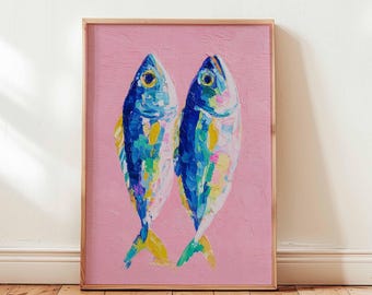 May include: A framed artwork featuring two stylized fish painted in vibrant blues, yellows, and greens against a pink background. The fish are depicted with thick brushstrokes, giving the piece a textured appearance. The frame is a natural wood color.