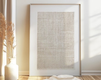 Puede incluir: Una obra de arte abstracta enmarcada con un patrón de cuadrícula en tonos neutros. La obra de arte se exhibe contra una pared blanca, con un jarrón de plantas secas y una tela drapeada en primer plano. El marco es plateado.