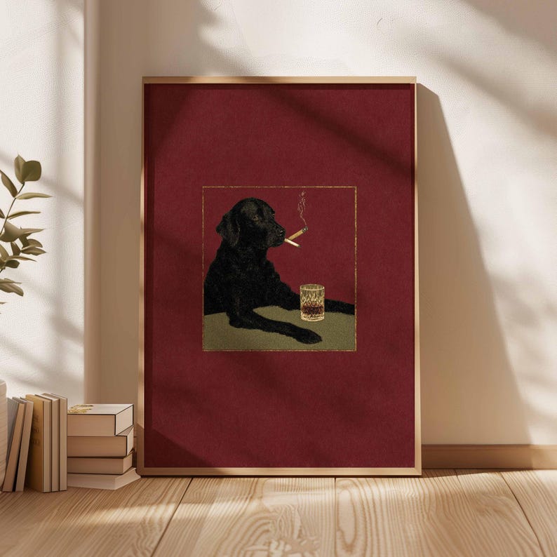 Puede incluir: Impresi&oacute;n art&iacute;stica enmarcada que representa un Labrador Retriever negro con un cigarrillo encendido y un vaso de whisky. La imagen est&aacute; sobre un fondo burdeos con un borde dorado. La obra de arte tiene un estilo ilustrativo vintage.