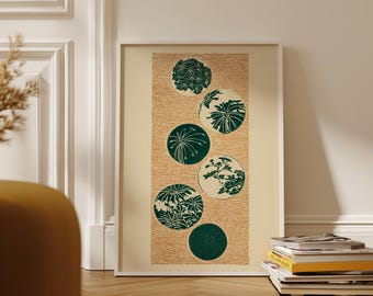 May include: A framed art print featuring a series of green botanical designs within circular shapes. The circles are arranged vertically against a textured beige background. The artwork is displayed in a white frame, leaning against a wall.