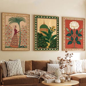 May include: Three framed wall art prints featuring intricate botanical and architectural illustrations. The left print shows a person standing by a palm tree, the center depicts a domed building with foliage, and the right displays a large white flower.