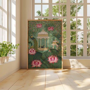 Pu&ograve; includere: Una stampa artistica incorniciata con una serena scena di giardino. L'opera presenta un gazebo, pavoni e fiori di loto nei toni del verde, rosa e oro. La stampa &egrave; esposta in una stanza con luce naturale da una grande finestra.