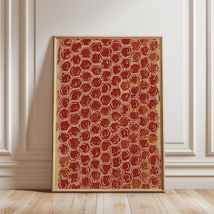 Könnte beinhalten: Gerahmtes Kunstwerk mit einem sich wiederholenden Muster aus roten Bienenwaben. Die Zellen sind in einem dunkleren Rot umrandet, mit einer helleren roten Füllung. Das Kunstwerk wird in einem hellbraunen Holzrahmen vor einer weißen Wand und einem Holzboden präsentiert.
