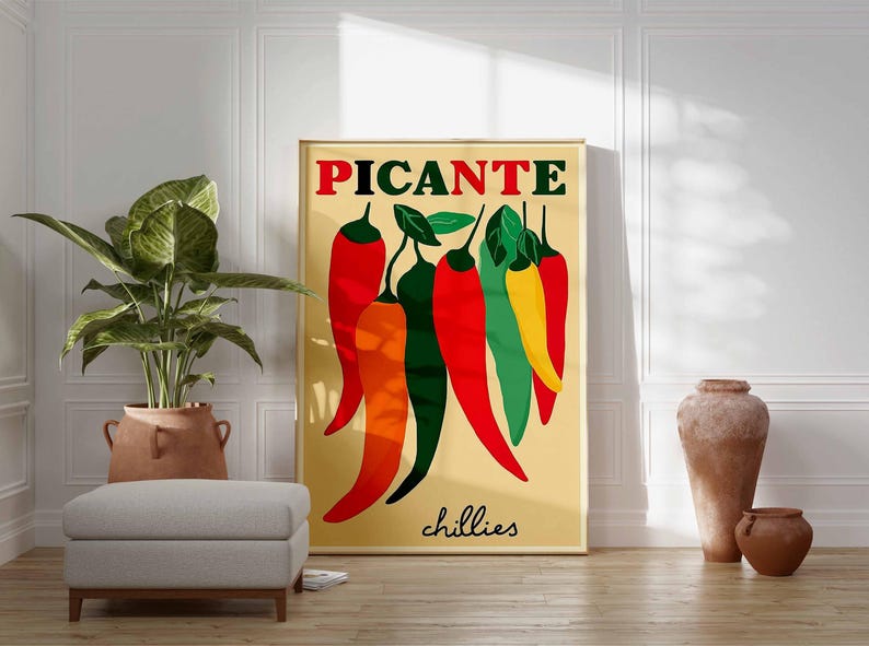May include: A framed art print featuring a stylized illustration of chili peppers in red, orange, green, and yellow against a beige background. The word "PICANTE" is at the top in red letters, with "chillies" in black at the bottom.