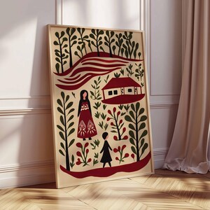 Op de afbeelding: Een ingelijste kunstdruk met een landschap in folk-art-stijl met een rood huis, figuren en gestileerde bomen. Het kunstwerk heeft een cr&egrave;mekleurige achtergrond met rode, zwarte en groene elementen. Het frame is licht van kleur.