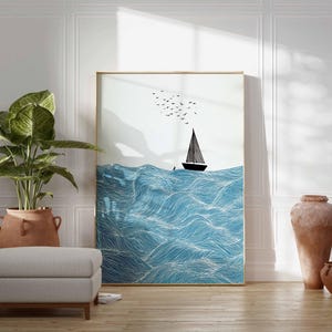 May include: A framed art print featuring a sailboat on a wavy blue sea, with birds in the sky. The artwork is displayed in a room with a large potted plant, a gray ottoman, and decorative vases. The frame has a gold finish.