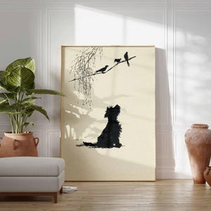 K&ouml;nnte beinhalten: Gerahmter Kunstdruck mit einer schwarzen Silhouette eines Hundes, der zu V&ouml;geln auf einem Ast aufblickt. Das Kunstwerk hat einen minimalistischen Stil mit einer neutralen Farbpalette und wird in einem Raum mit einer Topfpflanze, einem Hocker und dekorativen Vasen ausgestellt.
