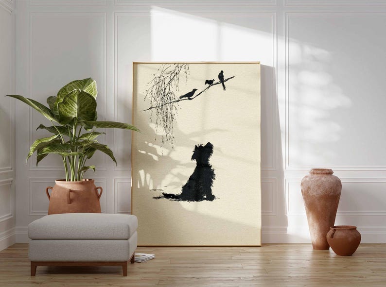 K&ouml;nnte beinhalten: Gerahmter Kunstdruck mit einer schwarzen Silhouette eines Hundes, der zu V&ouml;geln auf einem Ast aufblickt. Das Kunstwerk hat einen minimalistischen Stil mit einer neutralen Farbpalette und wird in einem Raum mit einer Topfpflanze, einem Hocker und dekorativen Vasen ausgestellt.