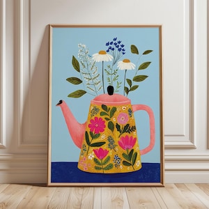 May include: Framed art print showing a pink teapot filled with flowers. The teapot is yellow with floral patterns, set against a light blue background. The artwork is presented in a wooden frame, suitable for home decor.