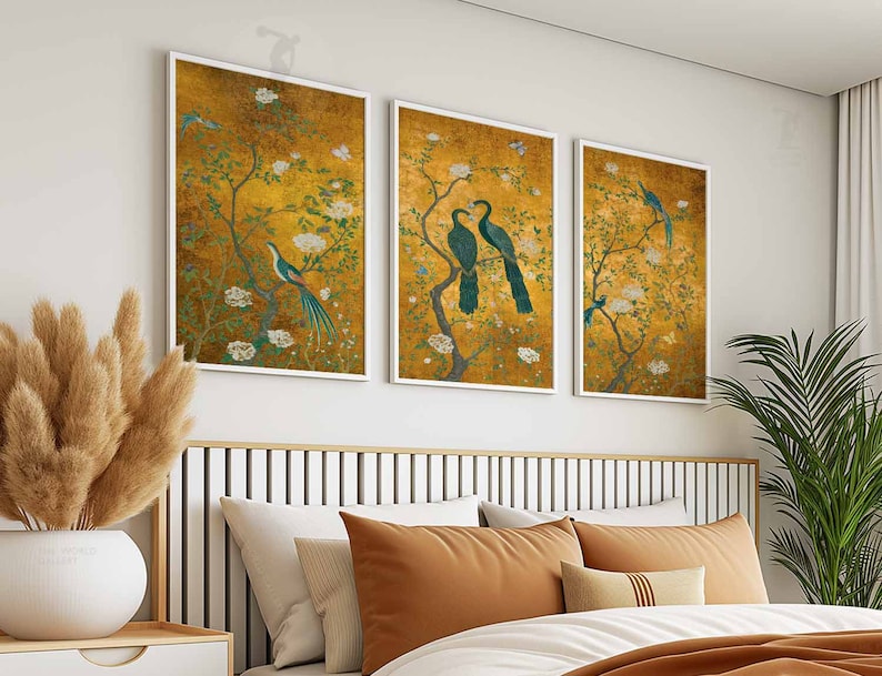 May include: Three framed prints with a gold background and floral designs. Each print features a pair of birds with long, flowing tails. The birds are depicted in shades of blue and green.