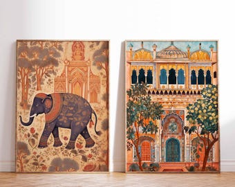 May include: Two framed prints with an Indian theme. The print on the left features a blue elephant with floral patterns in a forest setting. The print on the right shows a colorful building with intricate details and arches.