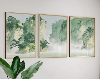 Könnte beinhalten: Set aus drei gerahmten Landschaftskunst-Drucken. Jeder Druck zeigt eine ruhige Berglandschaft mit grüner Vegetation und nebligen Wasserfällen. Das Kunstwerk ist goldgerahmt und an einer weißen Wand montiert.