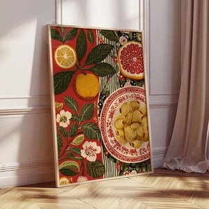 Może przedstawiać: Oprawiony wydruk artystyczny przedstawiający martwą naturę. Grafika przedstawia talerz makaronu, owoce cytrusowe i elementy kwiatowe na czerwonym tle. Wydruk jest w drewnianej ramie i opiera się o białą ścianę.