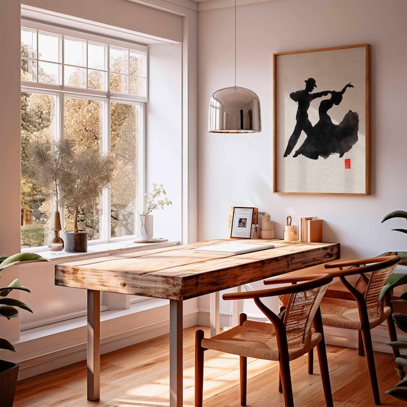 K&ouml;nnte beinhalten: Ein Raum mit einem Holztisch und zwei St&uuml;hlen. Ein gerahmtes Kunstwerk eines tanzenden Paares h&auml;ngt an der Wand. Ein gro&szlig;es Fenster bietet einen Blick auf B&auml;ume. Eine silberne Pendelleuchte h&auml;ngt &uuml;ber dem Schreibtisch.