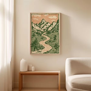 May include: A framed landscape art print featuring a mountain range, river, and trees. The artwork is in green and peach tones, with a detailed, etched style. The print is displayed in a light-colored wooden frame.