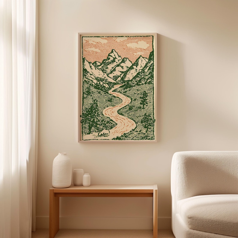 May include: A framed landscape art print featuring a mountain range, river, and trees. The artwork is in green and peach tones, with a detailed, etched style. The print is displayed in a light-colored wooden frame.