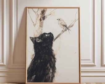 May include: Framed art print featuring a black cat looking up at a small bird perched on a branch. The artwork is in a watercolor style with neutral tones, set against a cream background. The frame is a light wood color.