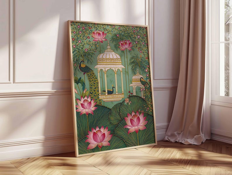 Pu&ograve; includere: Stampa artistica incorniciata con un'illustrazione dettagliata di un pavone, fiori di loto e un gazebo ornato. L'opera d'arte ha uno sfondo verde con dettagli rosa e oro. La stampa &egrave; presentata in una cornice di legno e poggia su un muro bianco.
