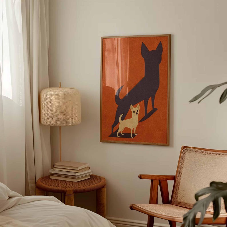 May include: A framed art print featuring a chihuahua dog with a dark shadow on an orange background. The artwork is displayed in a bedroom setting, with a wooden frame and a neutral color palette. A lamp and chair are also visible.