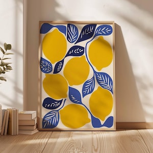 May include: A framed art print featuring a vibrant illustration of lemons and leaves. The lemons are a bright yellow, and the leaves are a deep blue, set against a cream background. The artwork is in a wooden frame.