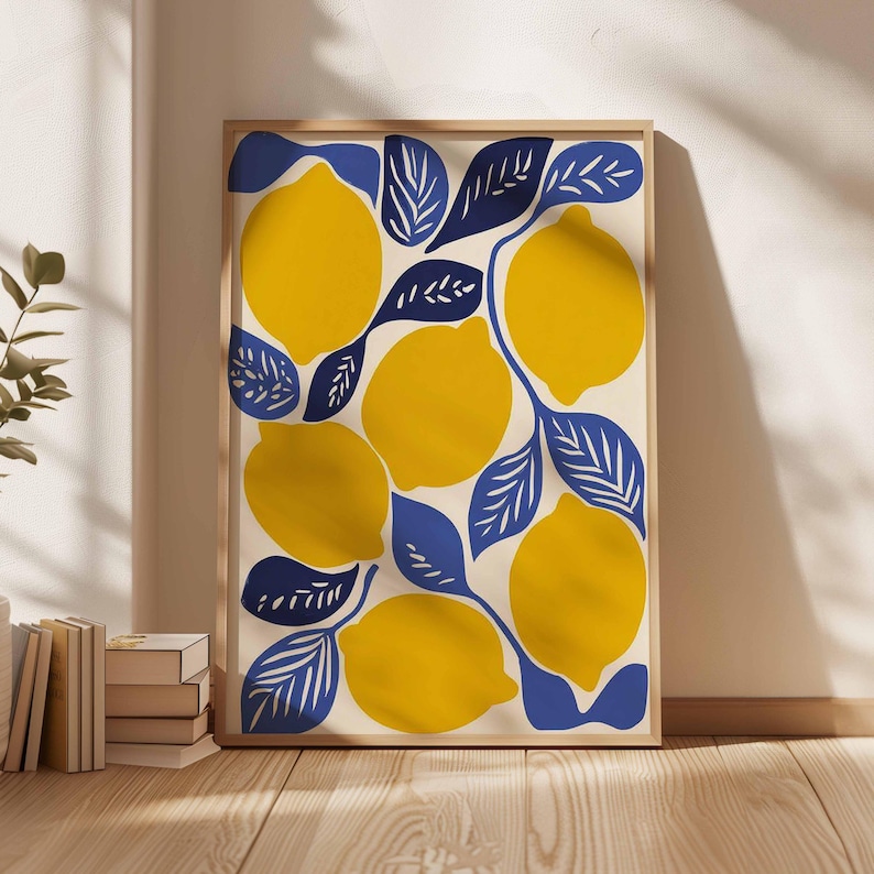 May include: A framed art print featuring a vibrant illustration of lemons and leaves. The lemons are a bright yellow, and the leaves are a deep blue, set against a cream background. The artwork is in a wooden frame.
