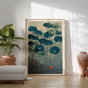 May include: A framed art print featuring a serene pond scene with large, teal lily pads and a small orange fish. The artwork has a vintage aesthetic, with a neutral color palette and a touch of gold. The print is displayed in a well-lit room.
