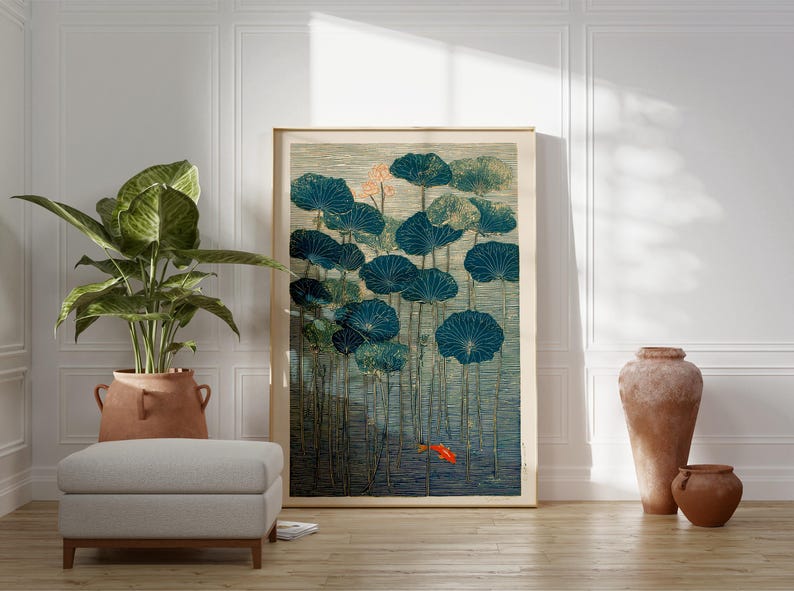 May include: A framed art print featuring a serene pond scene with large, teal lily pads and a small orange fish. The artwork has a vintage aesthetic, with a neutral color palette and a touch of gold. The print is displayed in a well-lit room.