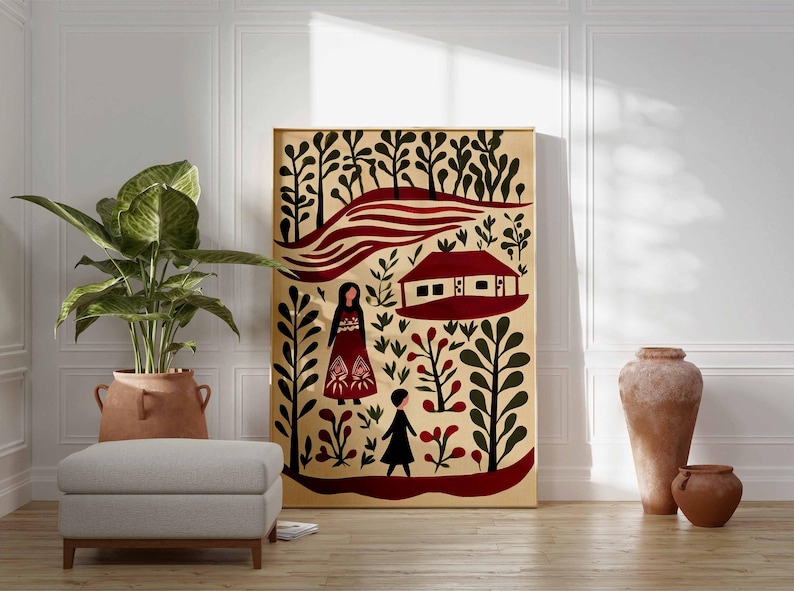 Op de afbeelding: Een ingelijste canvas kunstdruk met een illustratie in folk art-stijl. Het kunstwerk toont een huis, figuren en bladeren in rood, zwart en groen op een beige achtergrond. Een grote potplant, een poef en aardewerk staan ook in de afbeelding.