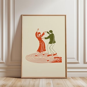 Könnte beinhalten: Ein gerahmter Druck mit einer Retro-Illustration eines tanzenden Paares. Das Paar tanzt in Rot und Grün auf einem Plattenspieler. Der Hintergrund ist cremefarben und der Rahmen hellbraun.