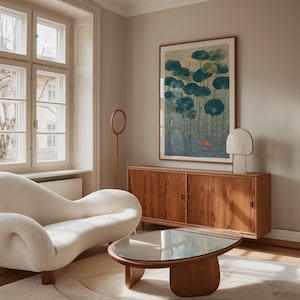 May include: A living room scene featuring a white, curved sofa, a wooden coffee table with a glass top, and a wooden cabinet. A framed artwork with blue and green lotus leaves and a small orange fish hangs above the cabinet. A white lamp and a wooden floor lamp are also present.