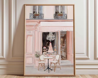 Puede incluir: Impresión enmarcada de una pastelería parisina rosa. La obra de arte representa una tienda con un toldo rosa, una lámpara de araña y una tarta de varios pisos en el escaparate. Dos sillas y una mesa pequeña están frente a la tienda. El marco es dorado.